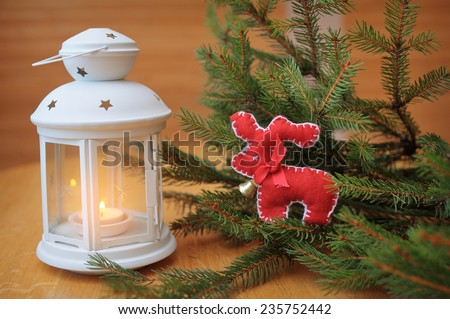 Burning white candles in a Christmas centerpiece deer.