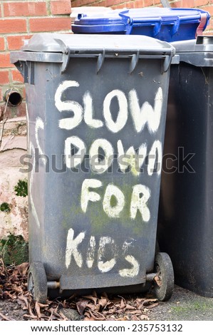 Slow down for kids written on a black bin