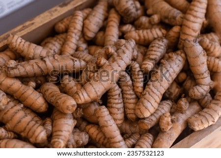 Fresh tumeric root in wooden box at market store