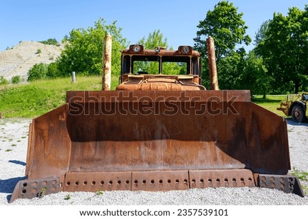Front view of big rusty bucket of old huge heavy crawler bulldozer, abandoned vintage earthmover dozer, industrial heavy machinery Royalty-Free Stock Photo #2357539101