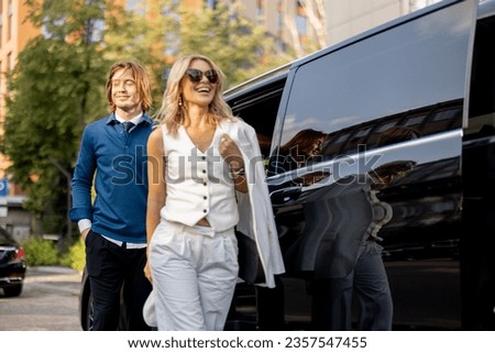 Business people get out of a minivan taxi, during a business trip by car. Concept of business trips and transportation Royalty-Free Stock Photo #2357547455