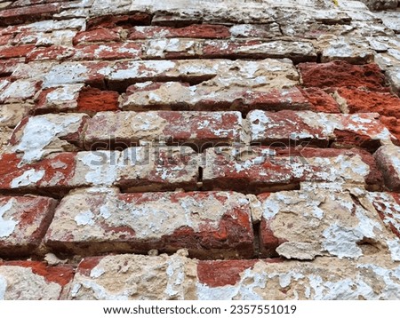 Old vintage background and texture with red bricks and remnants of white plaster. Abstract background, texture, frame, place for text, copy space