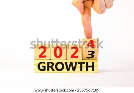 Planning 2024 growth new year symbol. Businessman turns a wooden cube and changes words Growth 2023 to Growth 2024. Beautiful white background, copy space. Business 2024 growth new year concept.