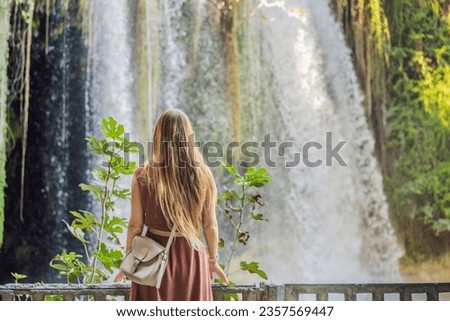 Beautiful woman with long hair on the background of Duden waterfall in Antalya. Famous places of Turkey. Apper Duden Falls
