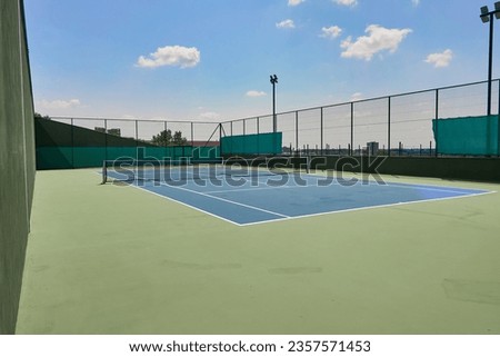                                big tennis court with blue sky and clouds Royalty-Free Stock Photo #2357571453