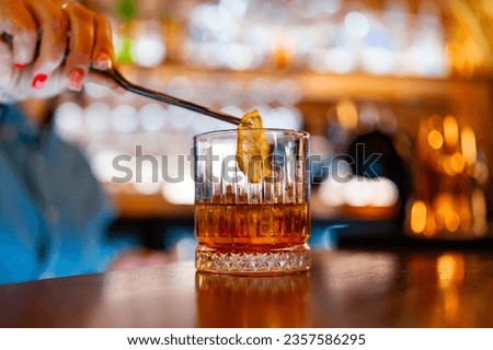 woman bartender hand making negroni cocktail. Negroni classic cocktail and gin short drink with sweet vermouth, red bitter liqueur in bar