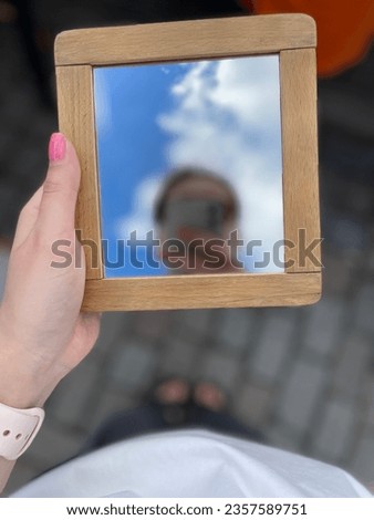 Photo in the mirror, the center of Prague, the girl in the reflection, the sky, blur.
