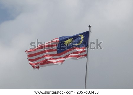 Malaysian flag waving with clouds and sky background