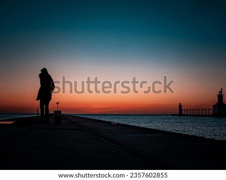 silhouette of me huddled for warmth on the pier