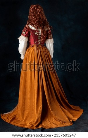 A mannequin wearing a red silk renaissance, Tudor, Georgian or fantasy style bodice and  Royalty-Free Stock Photo #2357603247