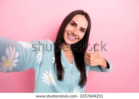 Photo of satisfied woman with long hairstyle dressed blue cardigan recording video blog show thumb up isolated on pink color background