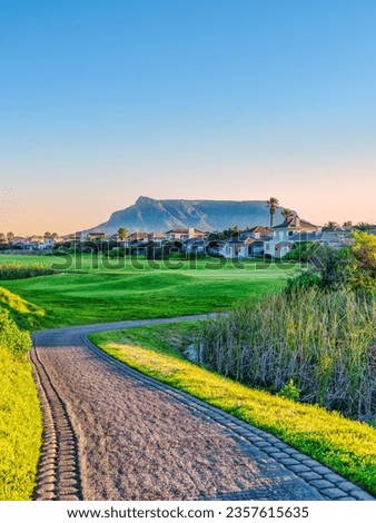 Vertical shot golf course and the table muntain in the background during sunset, Cape Town, South Africa Royalty-Free Stock Photo #2357615635