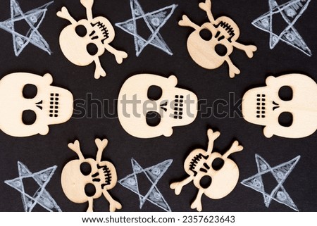 laser-cut wooden halloween embellishment ornaments or shapes arranged on black paper and esoteric stars