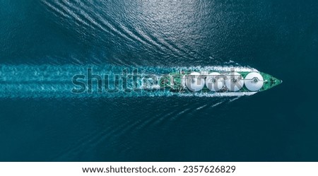 Aerial top view LNG Tanker ship (Liquefied Natural Gas) with contrail in the ocean sea ship carrying container and running for export from container international port to custom ocean concept  Royalty-Free Stock Photo #2357626829