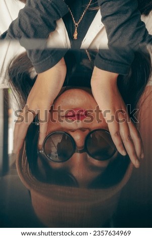 Young woman in 90s casual look photo concept wearing summer hat, sunglasses reflected in mirror. 