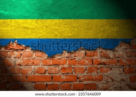 Old and damaged plaster on red brick wall with an image of an gabon flag. Royalty-Free Stock Photo #2357646009
