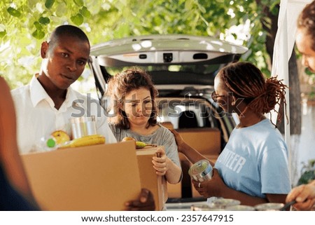 Empathy in action, as humanitarian aid team assists the poor by providing packages of meals to fight hunger and poverty. Food drive volunteers show compassion and aids the needy homeless people. Royalty-Free Stock Photo #2357647915