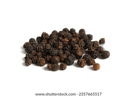 A bunch of black peppers with polka dots lie on a black background. Royalty-Free Stock Photo #2357665517