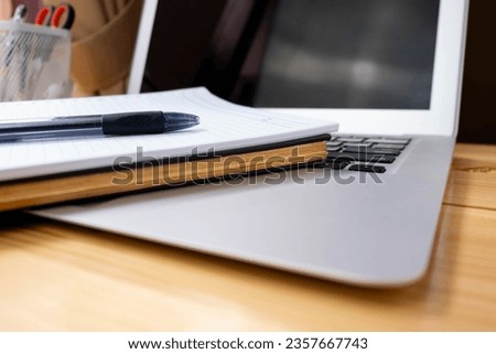Image of workplace in office room without people with open laptop, pencil and notebook lying on wooden desk