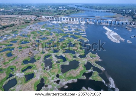 Aerial footage of the River Bhima and surrounding landscape including bridges at Daund India. Royalty-Free Stock Photo #2357691059