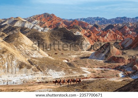 Travellers on camels in Colorful mountain in Danxia landform in Zhangye, Gansu of China. Silk road landscape, copy space for text, sunset picture
