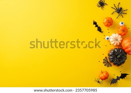 Step into allure of eerie Halloween nocturnal concept. Overhead snapshot highlighting pumpkin, bats, human eyes and Halloween decorations on yellow isolated backdrop, copyspace for advertising or text