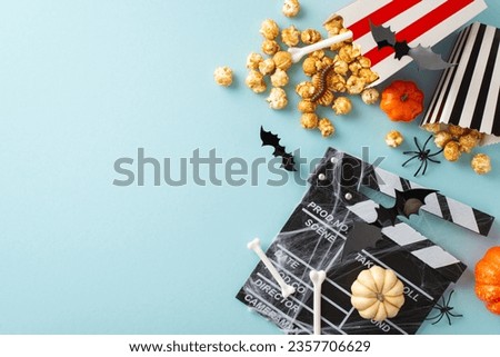 Pumpkin Patch Picture: Top view of Halloween cinema concept. Popcorn boxes with bone motifs, creepy-crawlies, and bats. Pumpkins, spiderweb, and clapperboard on pastel blue background, space for text