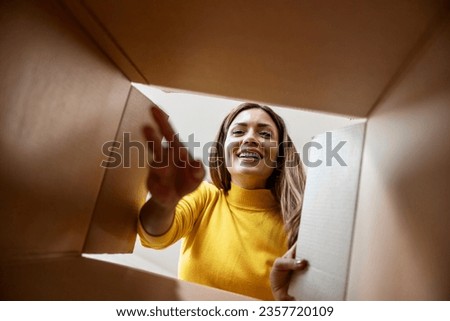 Woman with open box,view from inside.Excited girl unboxing cardboard delivery package. Royalty-Free Stock Photo #2357720109