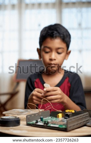 Little genius boy is repairing electronic devices                               