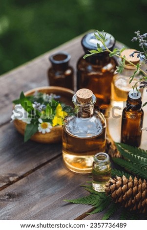 Concept of pure organic essential oil in glass bottles in cosmetology. Moisturising skin care, aromatherapy. Gentle body treatment. Atmosphere of harmony, relax. Wooden background, natural ingredients Royalty-Free Stock Photo #2357736489