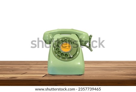 Green desk phone on a wooden table Isolated on a white background