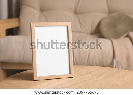 Empty square frame on wooden table indoors, space for text