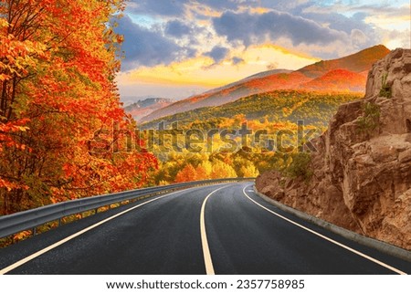 Black asphalt road landscape at sunset in beautiful colorful nature. Highway scenery among mountains in autumn season. Nature landscape on beautiful road in colorful fall. Autumn landscape in Germany. Royalty-Free Stock Photo #2357758985