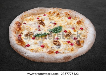 Pizza Four Cheese with smoked suluguni, gorgonzola, mozzarella, mountain ash, walnuts, honey, basil. Neapolitan round pizza on dark background