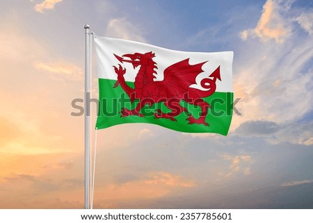 Wales flag waving on sundown sky Royalty-Free Stock Photo #2357785601