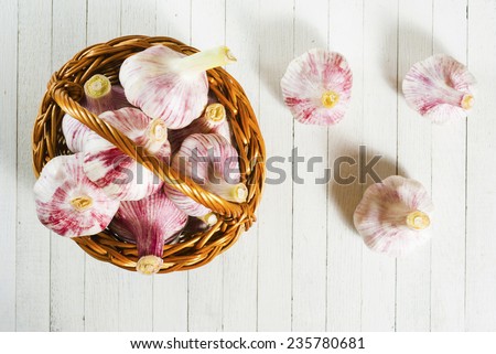 garlic bulbs and basket on rustic wooden table