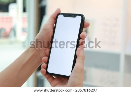 Hand holding phone white screen at home