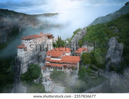 Meteora Monastery of Roussanou rising out of the mist. Aerial, mystical panoramic landscape.  A UNESCO World Heritage Site. Greece.