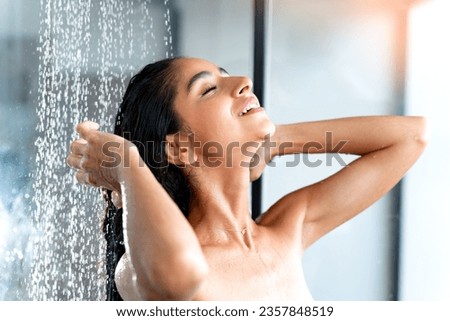 Showering and bathing with beautiful Indian woman taking shower in morning Royalty-Free Stock Photo #2357848519