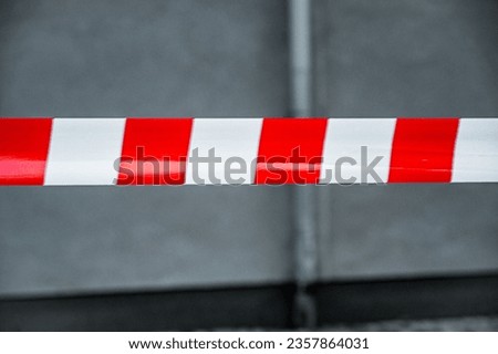 Red and White Lines of barrier tape. at street background. Red White warning tape pole fencing is protects for No entry