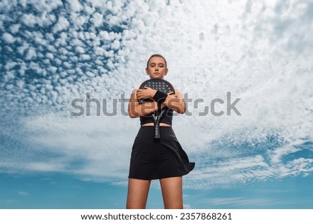 Padel tennis player with racket. Woman athlete with paddle racket on court outdoors. Sport concept. Download a high quality photo for the design of a sports app or web site.