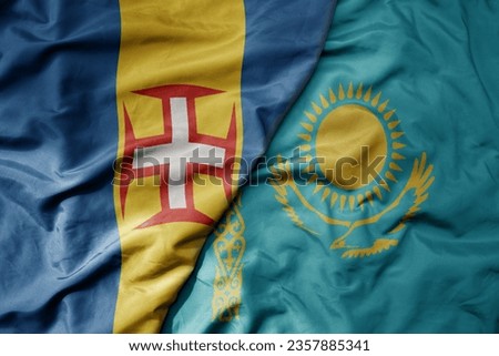 big waving national colorful flag of madeira and national flag of kazakhstan . macro