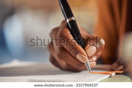 Close up of african american business woman hand writing on a contract while working in office. Successful black businesswoman signing documents using a pen while working from home, taking note. 
