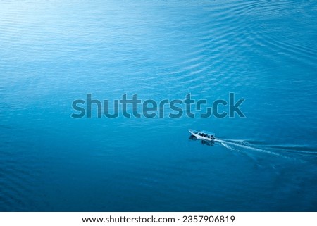 Top view, aerial view wooden fishing boat on the beach from a drone. Royalty high quality stock photo image of the wooden fishing boat on the beach. Fishing boat is mooring on clear blue beach alone