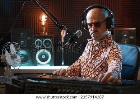 Professional musician working in the recording studio, he is playing the keyboard and recording a song