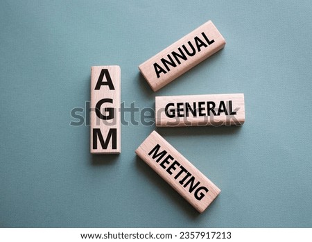 AGM - Annual general meeting symbol. Concept word AGM on wooden cubes. Beautiful grey green background. Business and AGM concept. Copy space. Royalty-Free Stock Photo #2357917213