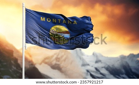 Flag of State of Montana on a flagpole against a colorful sky
