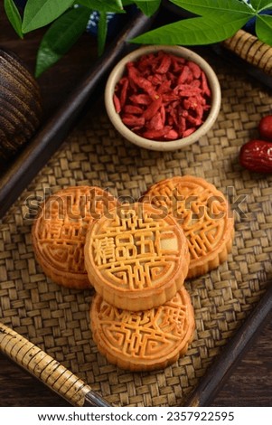 Mid-Autumn Festival mooncakes on a retro background. The Chinese meaning on the mooncakes in the picture is: fine five kernels, black sesame, rock sugar roses, representing the taste of mooncakes