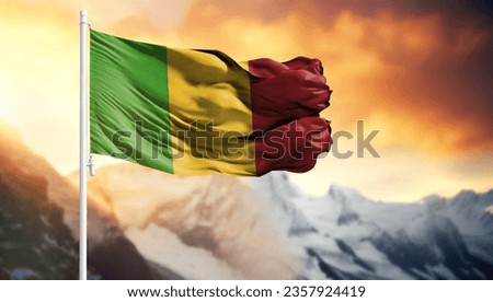 Flag of Mali on a flagpole against a colorful sky