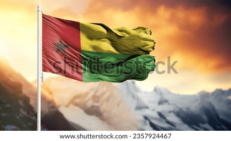 Flag of Guinea Bissau on a flagpole against a colorful sky